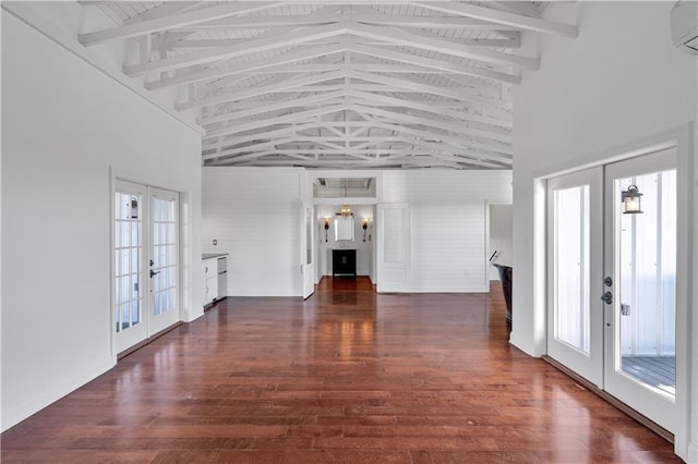 unfurnished living room with french doors, high vaulted ceiling, dark wood finished floors, beam ceiling, and a wall unit AC
