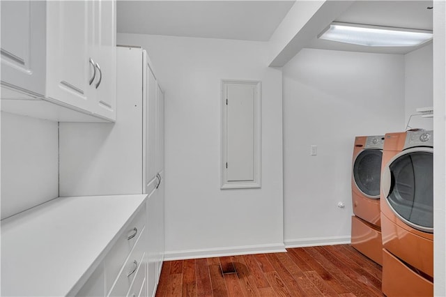 laundry room featuring cabinets, light hardwood / wood-style floors, and washing machine and dryer