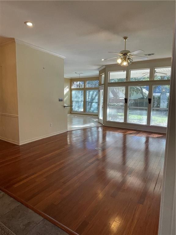 unfurnished room with ceiling fan, a healthy amount of sunlight, crown molding, and dark wood-type flooring