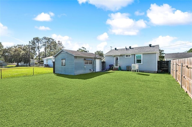 rear view of property featuring a yard and central air condition unit