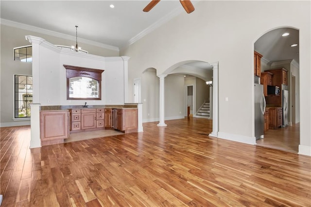 interior space featuring ceiling fan with notable chandelier, light hardwood / wood-style floors, stainless steel refrigerator, and crown molding