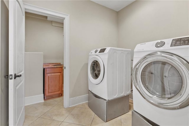 clothes washing area featuring independent washer and dryer and light tile patterned floors