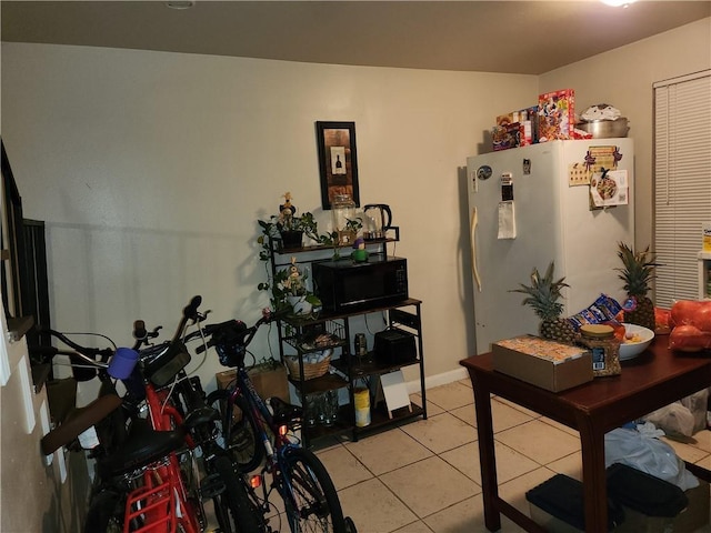 kitchen with light tile patterned floors and white fridge