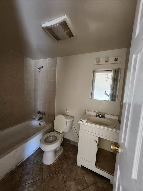full bathroom featuring toilet, tiled shower / bath, tile patterned flooring, and vanity