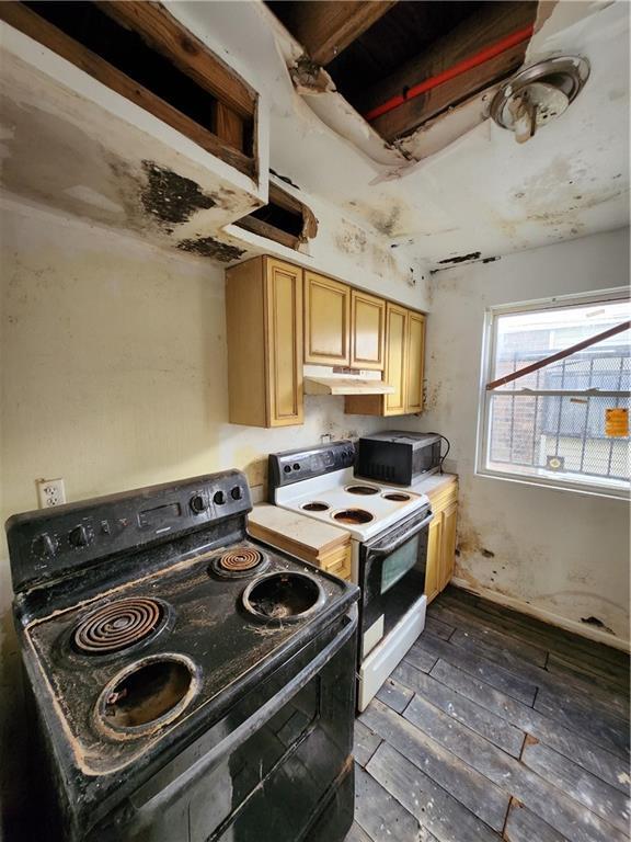 kitchen featuring dark wood-type flooring, electric range, light brown cabinetry, and black electric range