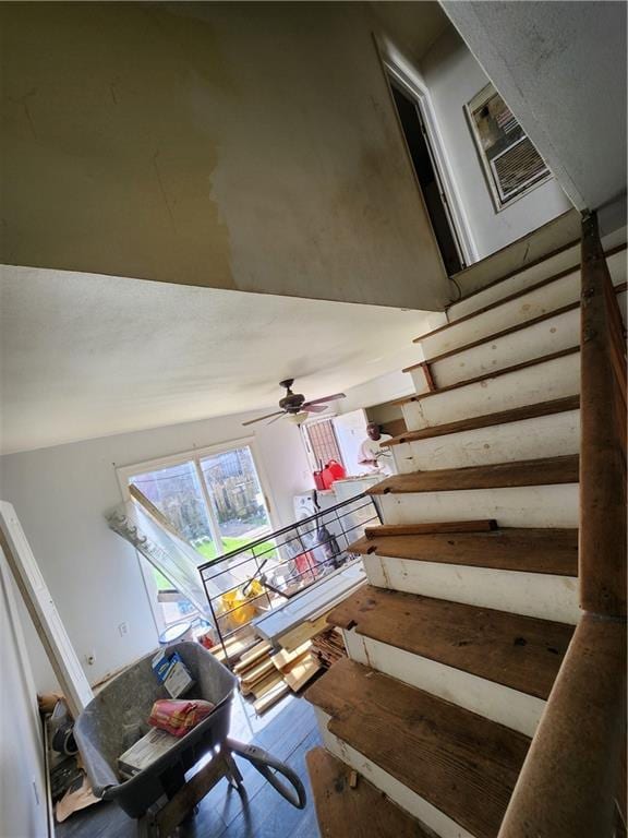 stairway featuring ceiling fan