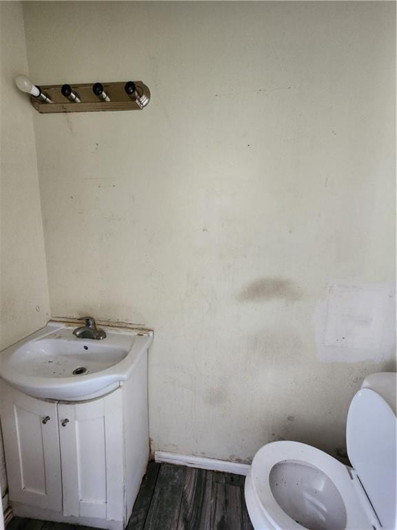 bathroom featuring hardwood / wood-style flooring, toilet, and vanity