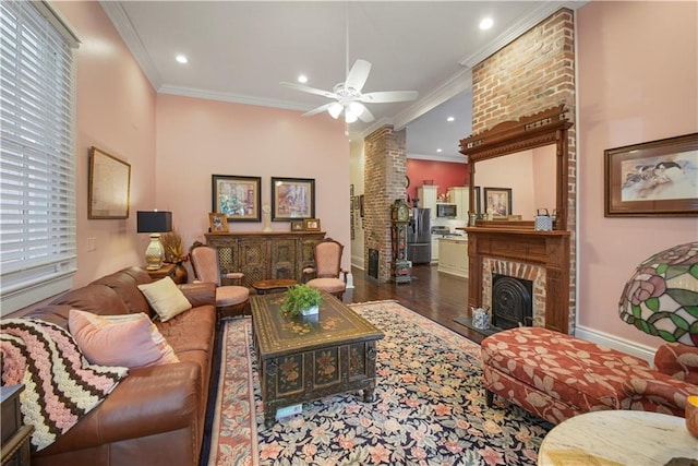 living room with a fireplace, ceiling fan, ornamental molding, and dark wood-type flooring