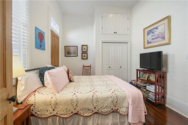 bedroom with dark hardwood / wood-style flooring and a closet