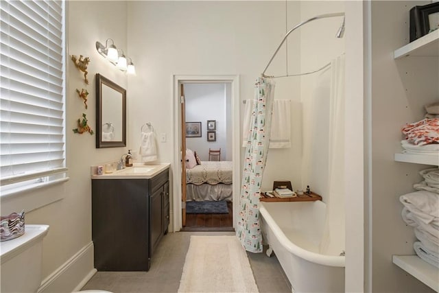 bathroom with shower / bath combo with shower curtain, tile patterned flooring, and vanity