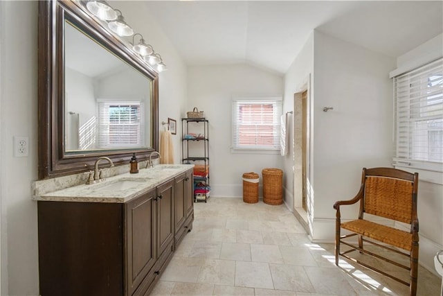 bathroom featuring tile patterned floors, a wealth of natural light, vanity, and vaulted ceiling