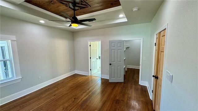 unfurnished bedroom with dark hardwood / wood-style floors, a raised ceiling, and wooden ceiling