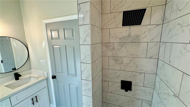 bathroom featuring a tile shower and vanity