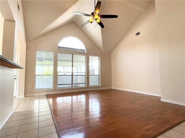 spare room featuring ceiling fan, high vaulted ceiling, wood finished floors, visible vents, and baseboards