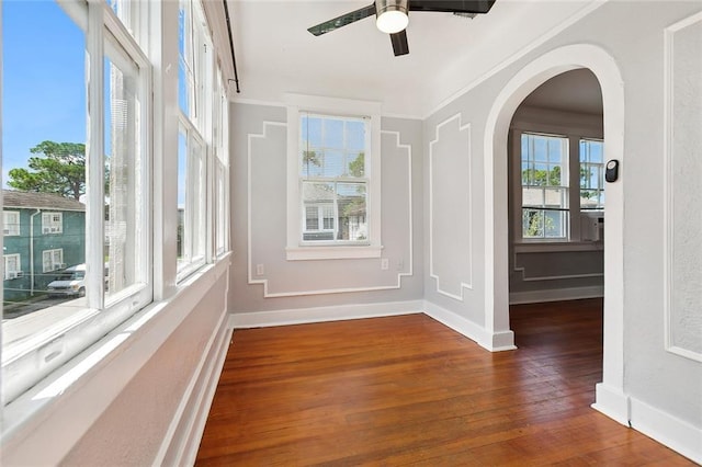 unfurnished sunroom featuring ceiling fan