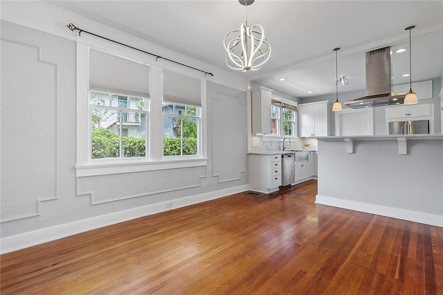 unfurnished dining area with sink, a healthy amount of sunlight, dark hardwood / wood-style floors, and a notable chandelier