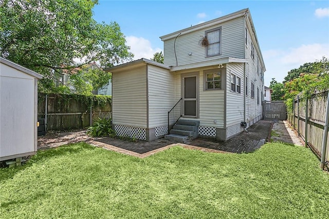 back of property with a yard and a storage shed