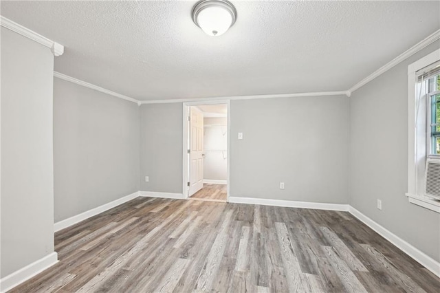 unfurnished room featuring crown molding, hardwood / wood-style floors, and a textured ceiling