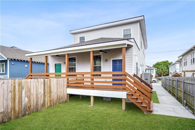 rear view of house featuring a lawn, ceiling fan, and a wooden deck