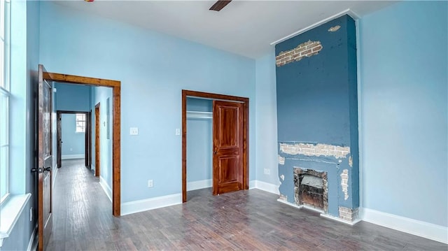 unfurnished bedroom featuring ceiling fan, dark wood-type flooring, and a closet