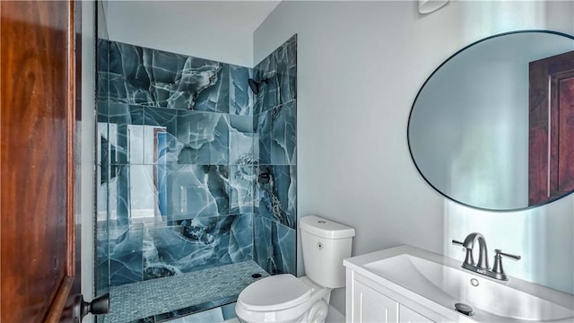 bathroom featuring tiled shower, vanity, and toilet