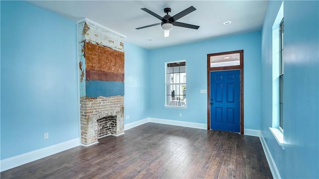 unfurnished living room featuring ceiling fan, a fireplace, and dark wood-type flooring