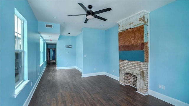 unfurnished living room featuring dark hardwood / wood-style floors, ceiling fan, and a brick fireplace