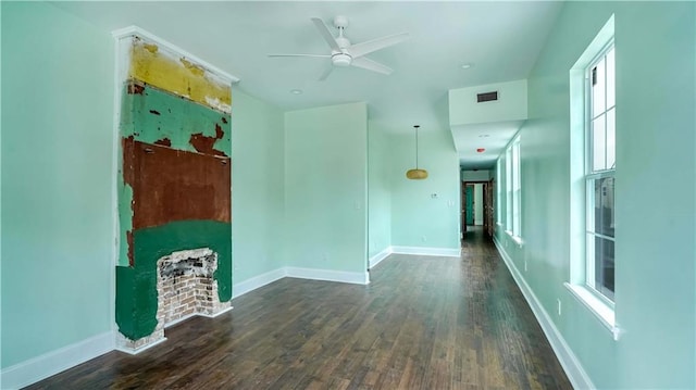 unfurnished living room featuring ceiling fan and dark wood-type flooring