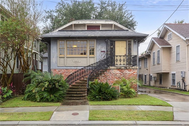 2808 Octavia St, New Orleans, LA 70115 - view of front of house featuring stucco siding, brick siding, and roof with shingles