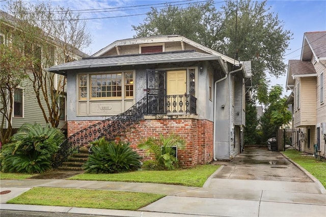 2808 Octavia St, New Orleans, LA 70115 - view of front of property with brick siding, stucco siding, and driveway