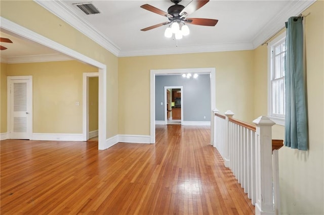 spare room featuring light hardwood / wood-style flooring, ceiling fan, and crown molding