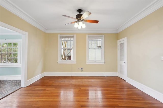 spare room featuring a wealth of natural light, hardwood / wood-style floors, and crown molding