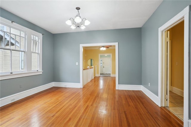 unfurnished dining area with light hardwood / wood-style floors and ceiling fan with notable chandelier