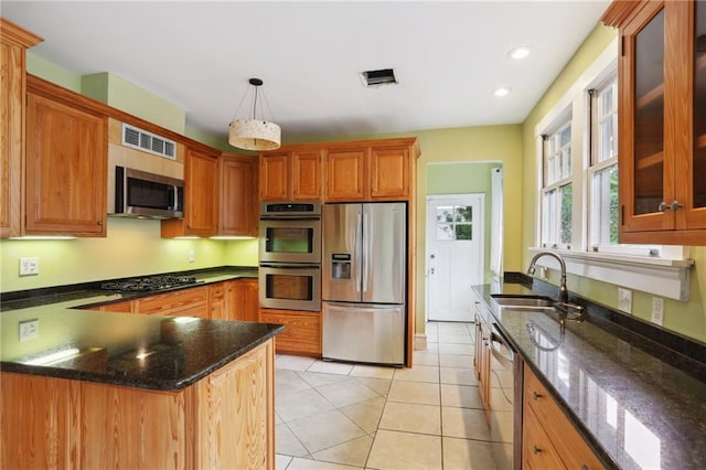 2808 Octavia St, New Orleans, LA 70115 - kitchen featuring stainless steel appliances, glass insert cabinets, a peninsula, dark stone countertops, and light tile patterned floors