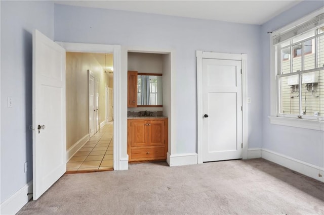 unfurnished bedroom with connected bathroom and light colored carpet