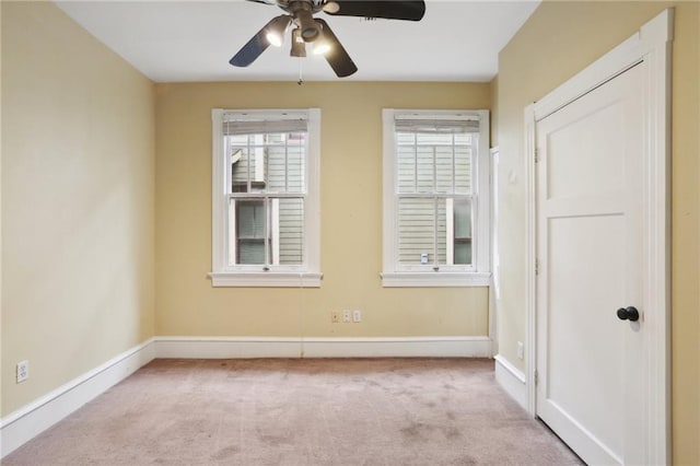 empty room featuring ceiling fan and light colored carpet