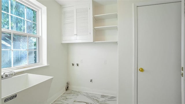 clothes washing area with plenty of natural light, cabinets, and sink