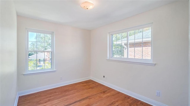 spare room with plenty of natural light and hardwood / wood-style flooring