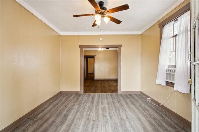 spare room with cooling unit, hardwood / wood-style floors, ornamental molding, and ceiling fan