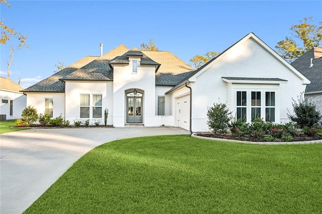 french country inspired facade featuring a front yard, french doors, and a garage