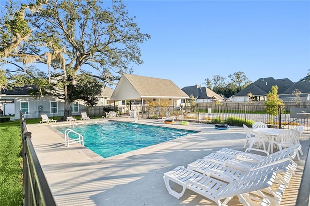 pool featuring a patio area, fence, and a residential view