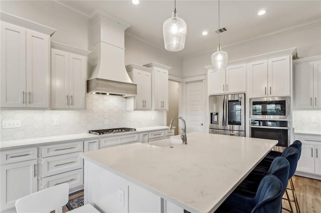 kitchen featuring custom range hood, ornamental molding, stainless steel appliances, and a sink