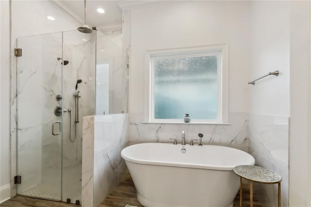 bathroom with tile walls, a marble finish shower, recessed lighting, a freestanding bath, and wood finished floors