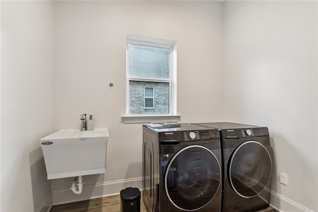 laundry area with laundry area, independent washer and dryer, wood finished floors, and baseboards