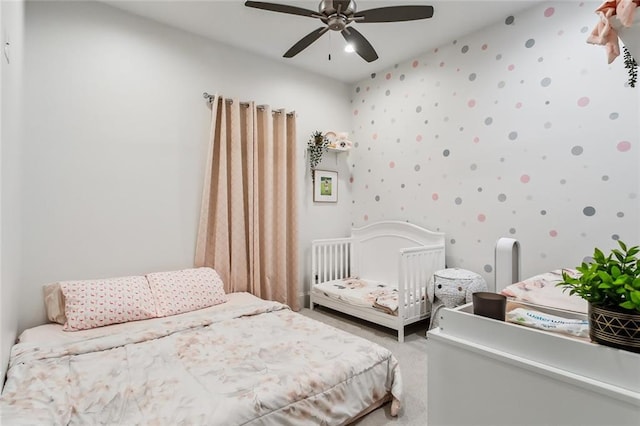 bedroom featuring light carpet, ceiling fan, and wallpapered walls