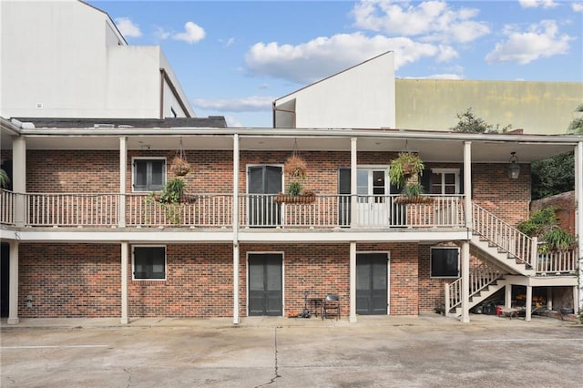 610 N Rampart St Unit F, New Orleans, LA 70112 - back of property featuring brick siding, stairway, and a balcony