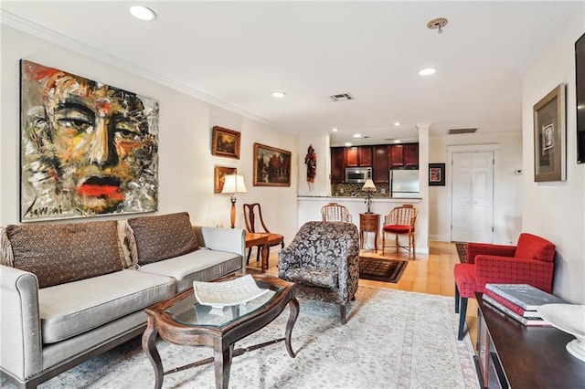 living room featuring light hardwood / wood-style flooring and ornamental molding