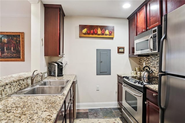 kitchen featuring light stone countertops, sink, electric panel, decorative backsplash, and appliances with stainless steel finishes