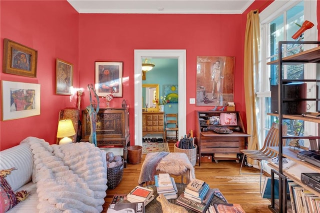 sitting room featuring crown molding and light hardwood / wood-style flooring