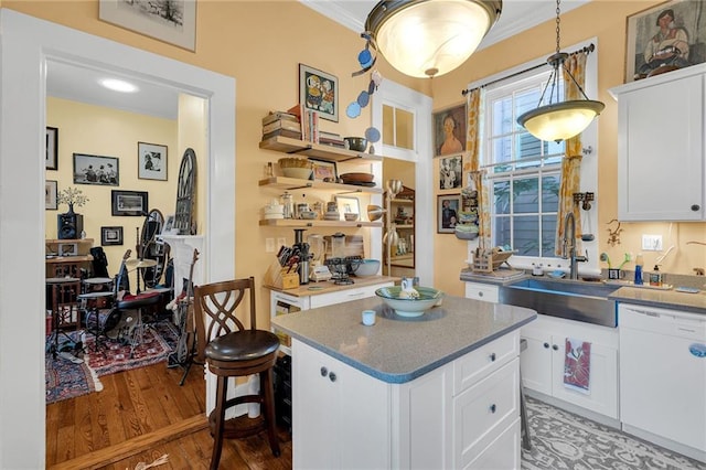 kitchen with a kitchen island, sink, dishwasher, hardwood / wood-style floors, and white cabinetry